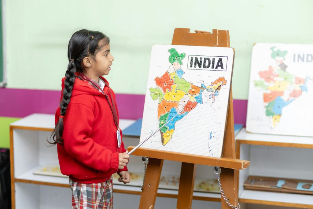 Young student points to India map in a classroom, fostering education.